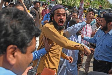 Supporters of Pakistan Tehreek-e-Insaf (PTI) party of Prime Minister Imran Khan shout slogans outside the Parliament House building in Islamabad on April 3, 2022. - Pakistan will go to the polls to elect a new government within three months after Prime Minister Imran Khan foiled an attempt to boot him from office April 3 by getting the president to dissolve the national assembly. (Photo by Aamir QURESHI / AFP)