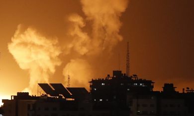 Smoke rises above buildings in Gaza City as Israel launches air strikes on the Palestinian enclave on late April 6, 2023. - Several explosions coming from Gaza were heard by AFP journalists on April 6, 2023, night, as the Israeli army said it was carrying out strikes in the area. The Israeli army "is currently striking in the Gaza Strip," read an army statement shortly after AFP heard at least three explosions. A Palestinian security source said the strikes had hit several Hamas training sites. (Photo by MOHAMMED ABED / AFP)
