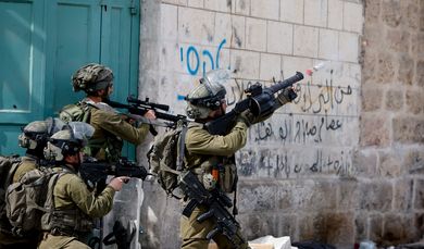 An Israeli soldier uses a weapon amid clashes with Palestinian protesters, in Hebron, in the Israeli- occupied West Bank April 1, 2022. REUTERS/Mussa Qawasma