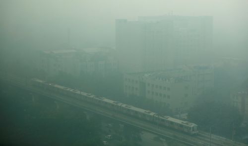 A metro train passes through the Rajiv Gandhi Cancer Institute and Research Center as it approaches Rithala metro station on a smoggy morning in Delhi, India November 12, 2021. REUTERS/Navesh Chitrakar