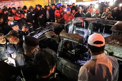 People, rescuers and security forces gather around a vehicle hit by a drone strike, reportedly killing three people, including two leaders of a pro-Iran group, in Baghdad on February 7, 2024. One of those killed was a commander of the Kataeb Hezbollah militant group in charge of military affairs in Syria, a member of the pro-Iran Iraqi group told AFP. The security sources also reported the deaths of two Kataeb Hezbollah members. (Photo by MURTAJA LATEEF / AFP) (Photo by MURTAJA LATEEF/AFP via Getty Images)